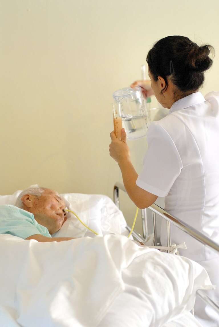 พยาบาลให้อาหารทางสายยางผู้ป่วยติดเตียงในห้องพักผู้สูงอายุ — บริการ NG tube feeding โกลเด้นไลฟ์โฮม