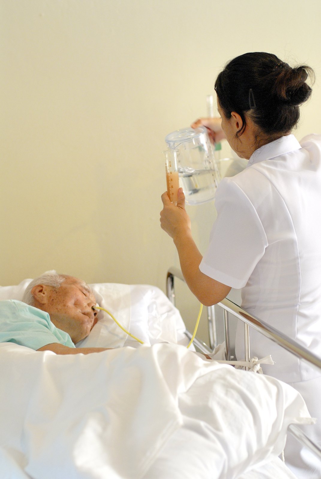พยาบาลให้อาหารทางสายยางผู้ป่วยติดเตียงในห้องพักผู้สูงอายุ — บริการ NG tube feeding โกลเด้นไลฟ์โฮม