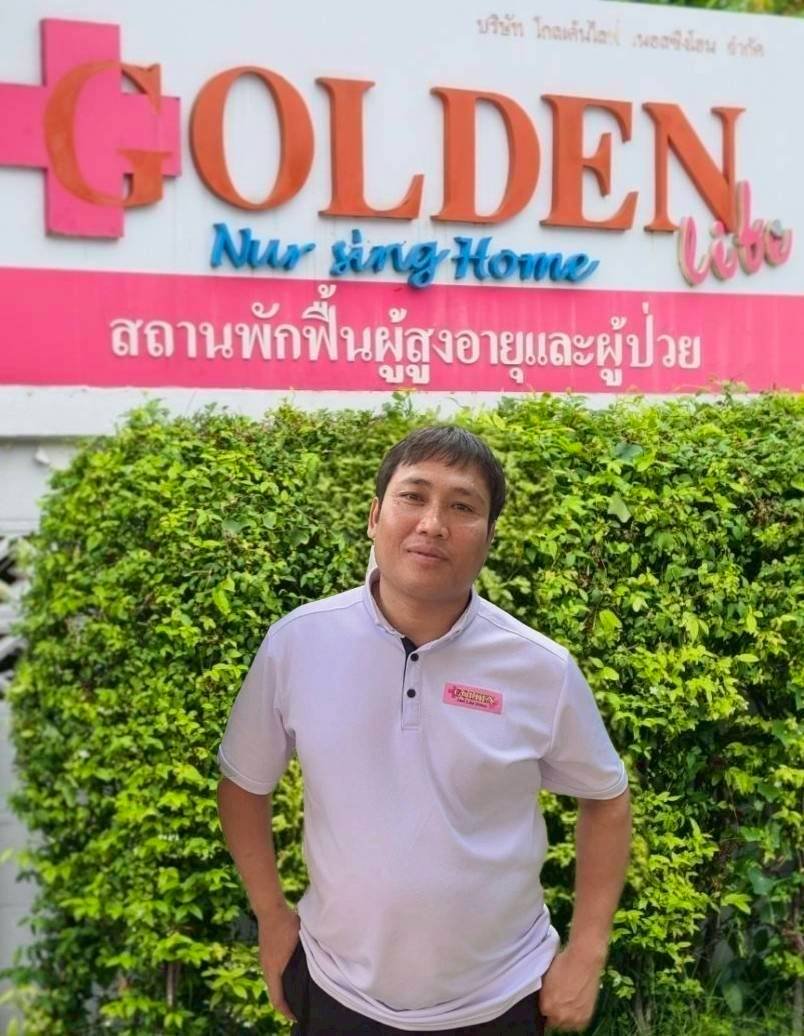 ผู้ช่วยพยาบาลชายโกลเด้นไลฟ์โฮมหน้าป้ายสถานพักฟื้น — ทีมดูแลผู้สูงอายุด้วยมาตรฐานวิชาชีพ